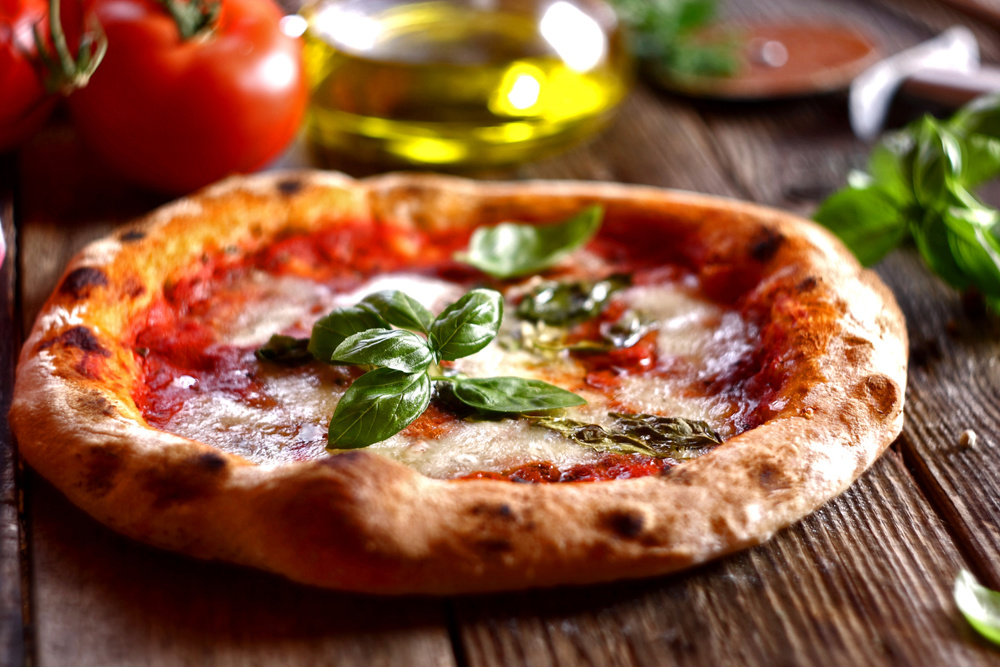 Neapolitan pizza with mozzarella, tomatoes and basil leaves.Homemade pizza margherita. Selective focus