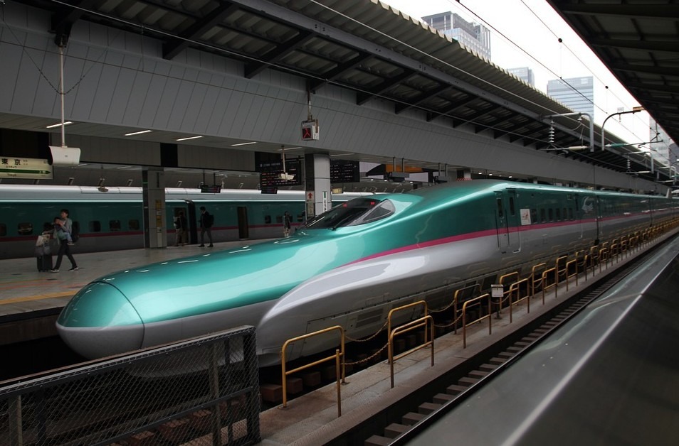 A green bullet train with people