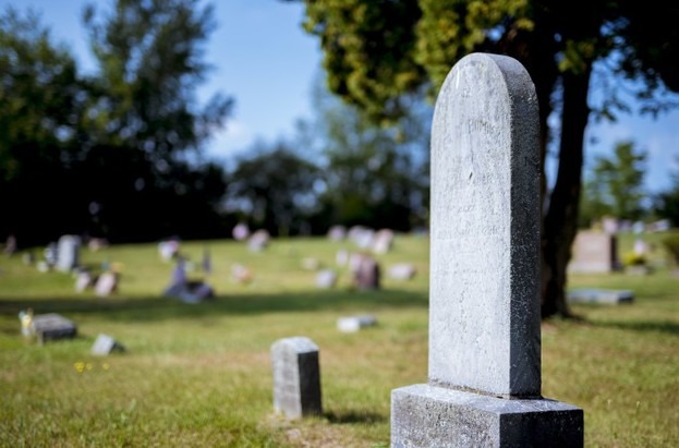 Closeup shot of a gravestone with blurred background in the daytime