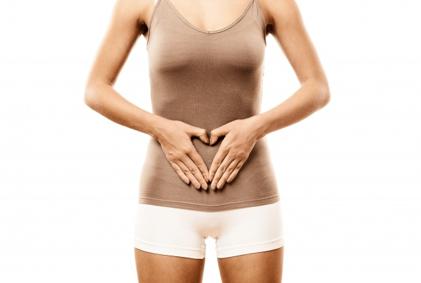 A woman with her hands placed on her stomach.