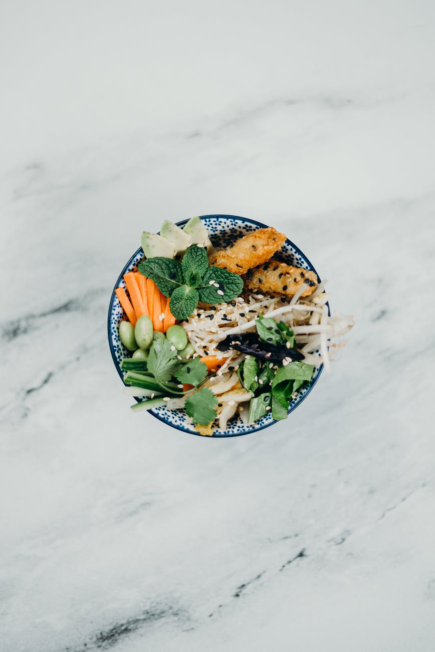 Vegetables such as carrots, leaves, cucumber, onions in a bowl