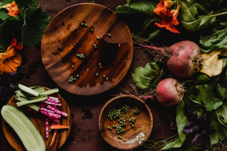 Sliced vegetables scattered on a wooden table.