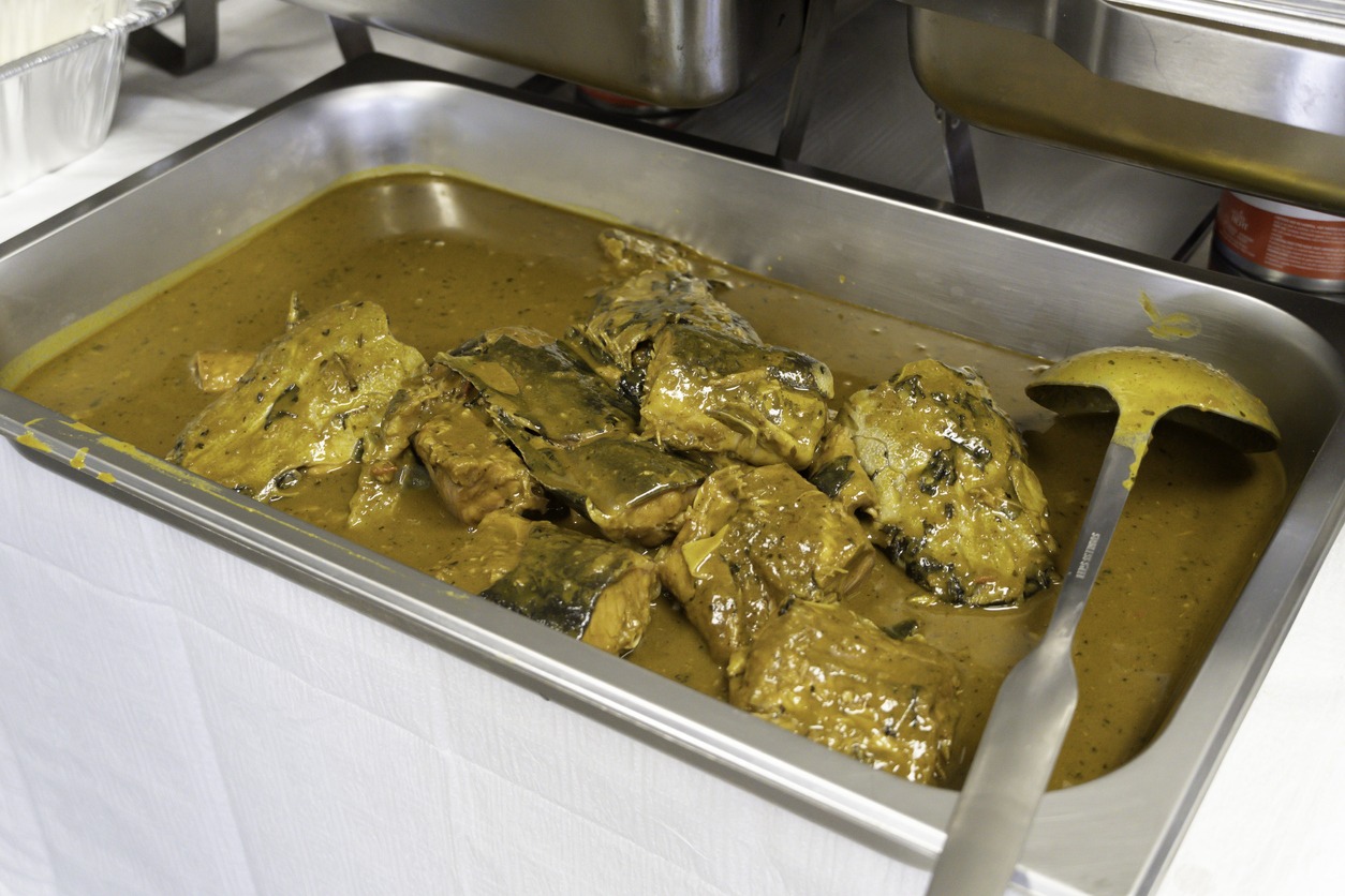 Nigerian Banga soup with fish in Chaffing Dish at Party