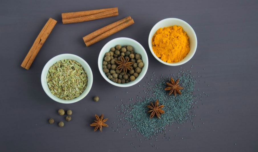 various herbs and spices in and near white bowls