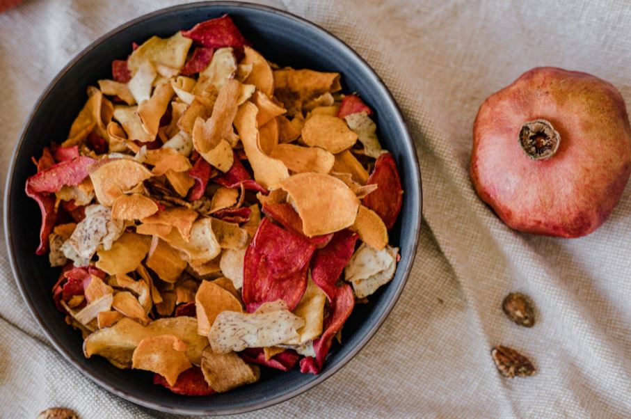 mixed vegetable chips in a bowl beside a vegetable