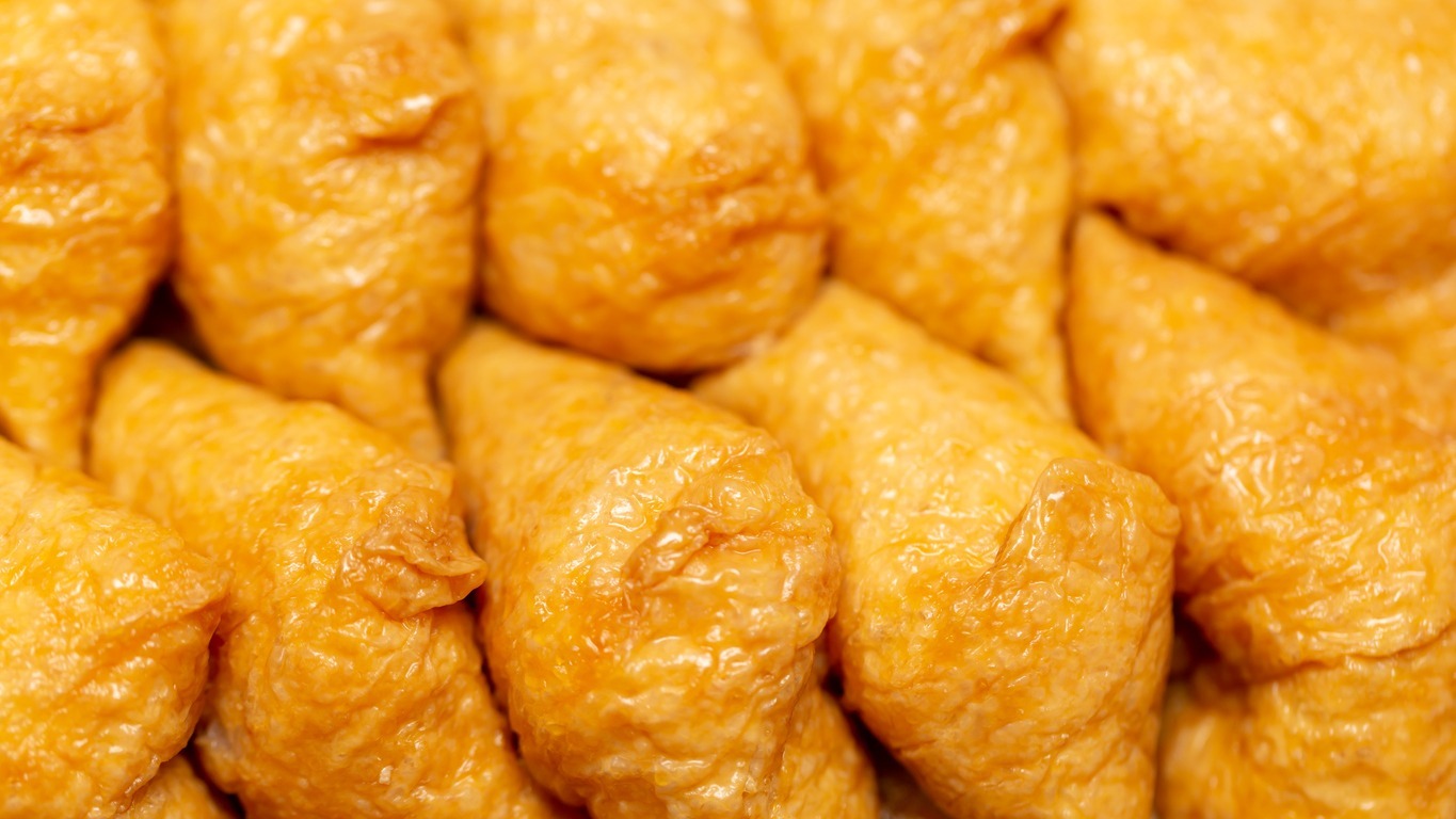 a close up of Inari sushi stacked together