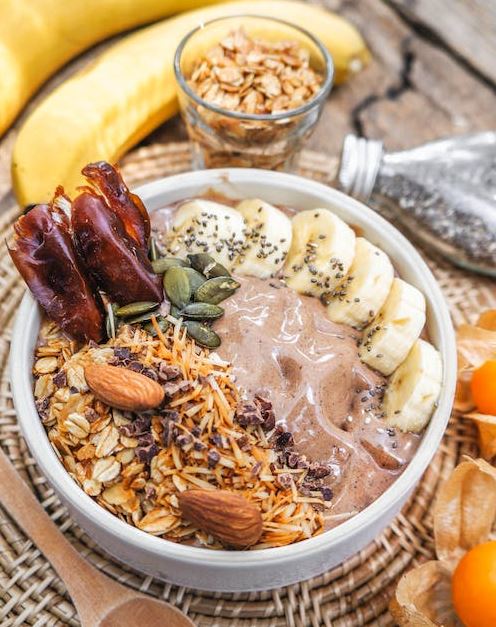 Bowl of nutritious smoothie with seeds and fruits on a braided mat