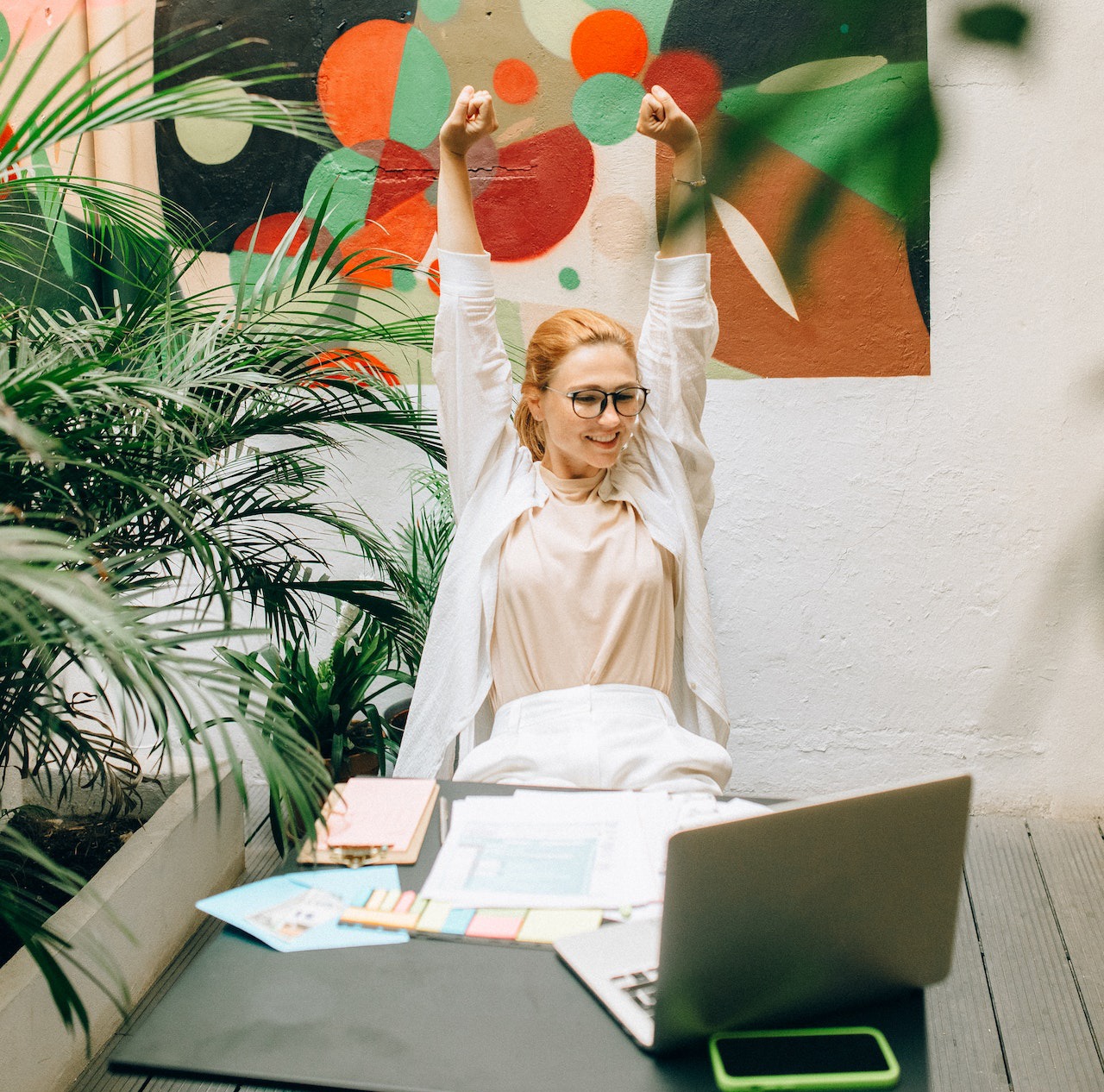 Woman in white jacket stretching her arms.