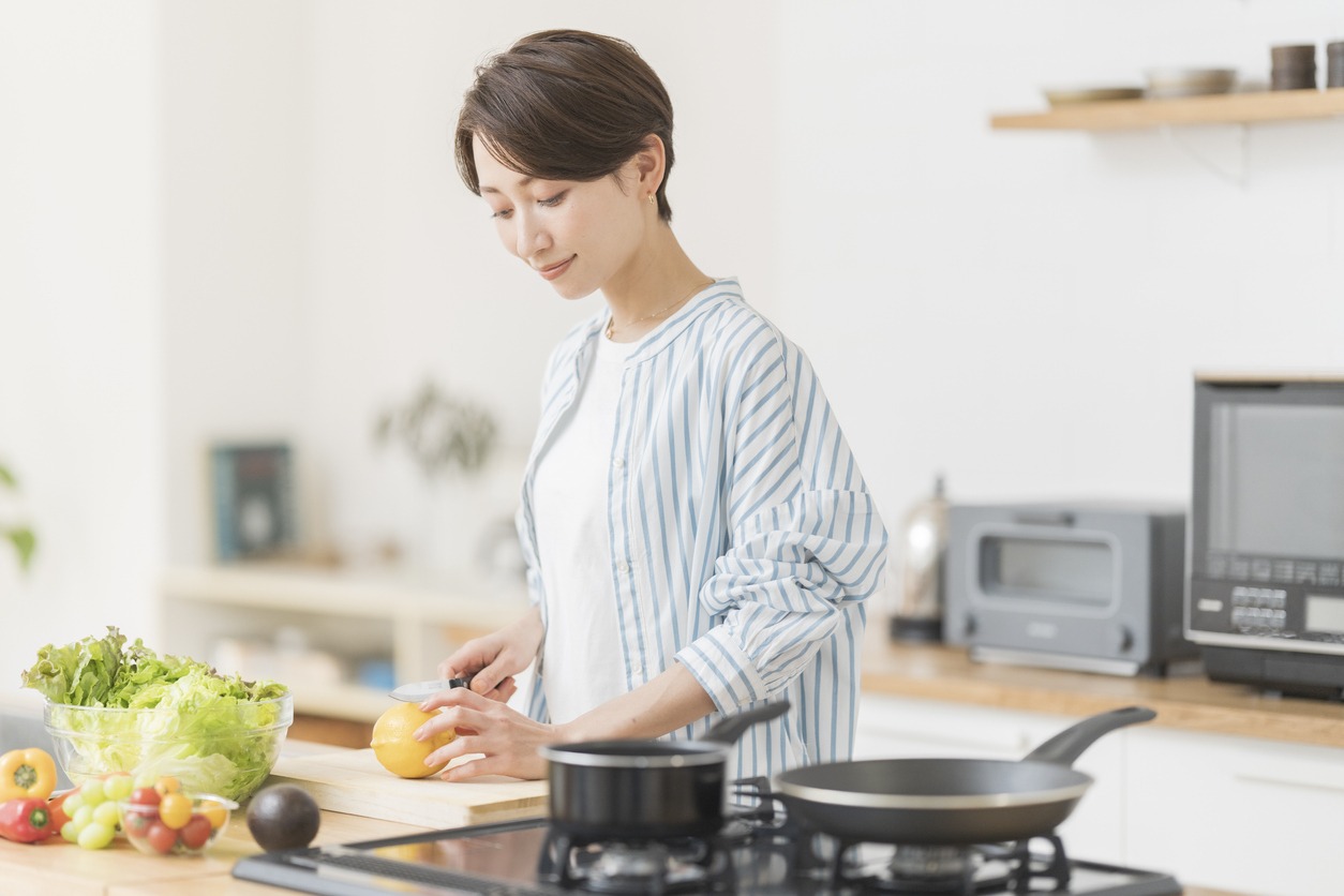 A woman standing in a kitchen next to a stove
