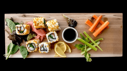 Sushi, soy sauce and vegetables.