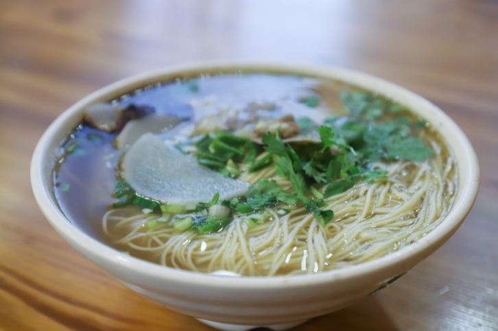A bowl of white soup noodles on a table
