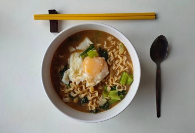 Noodle soup in a bowl with a spoon and chopsticks