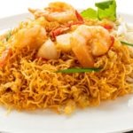 crispy noodles with shrimp, bean sprout, and garlic in a white ceramic plate