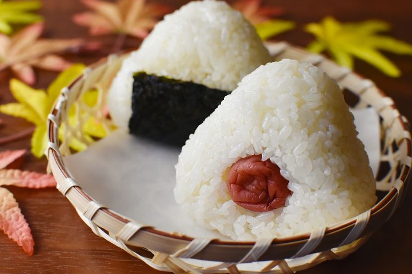 onigiri with different fillings in a wooden bowl basket