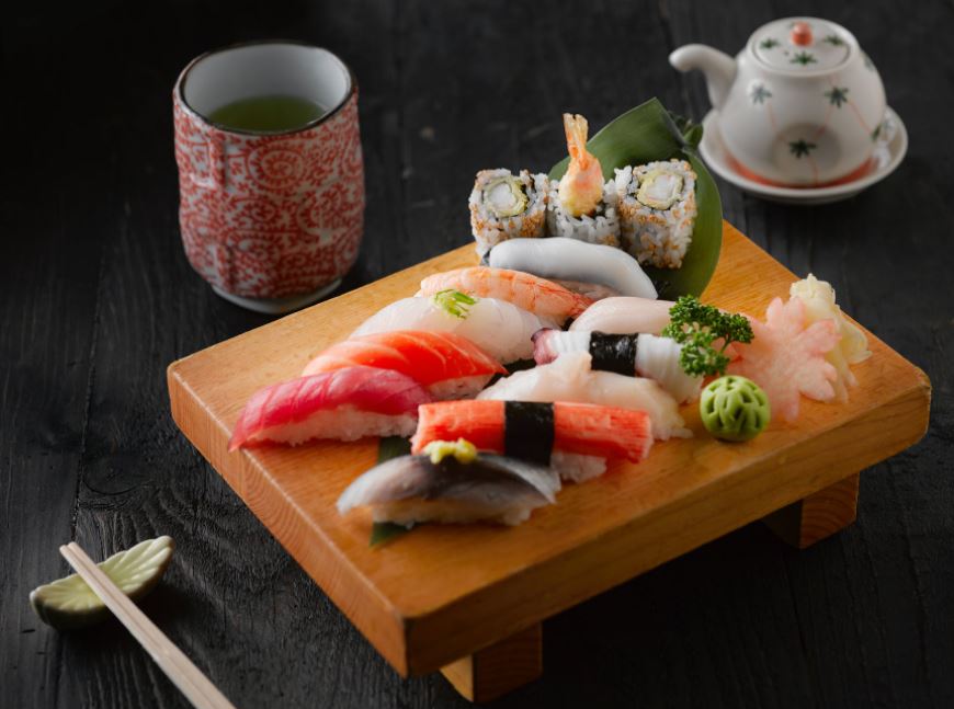 different types of sushi on brown wooden board