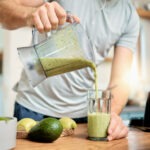 Man pouring healthy smoothie into a glass