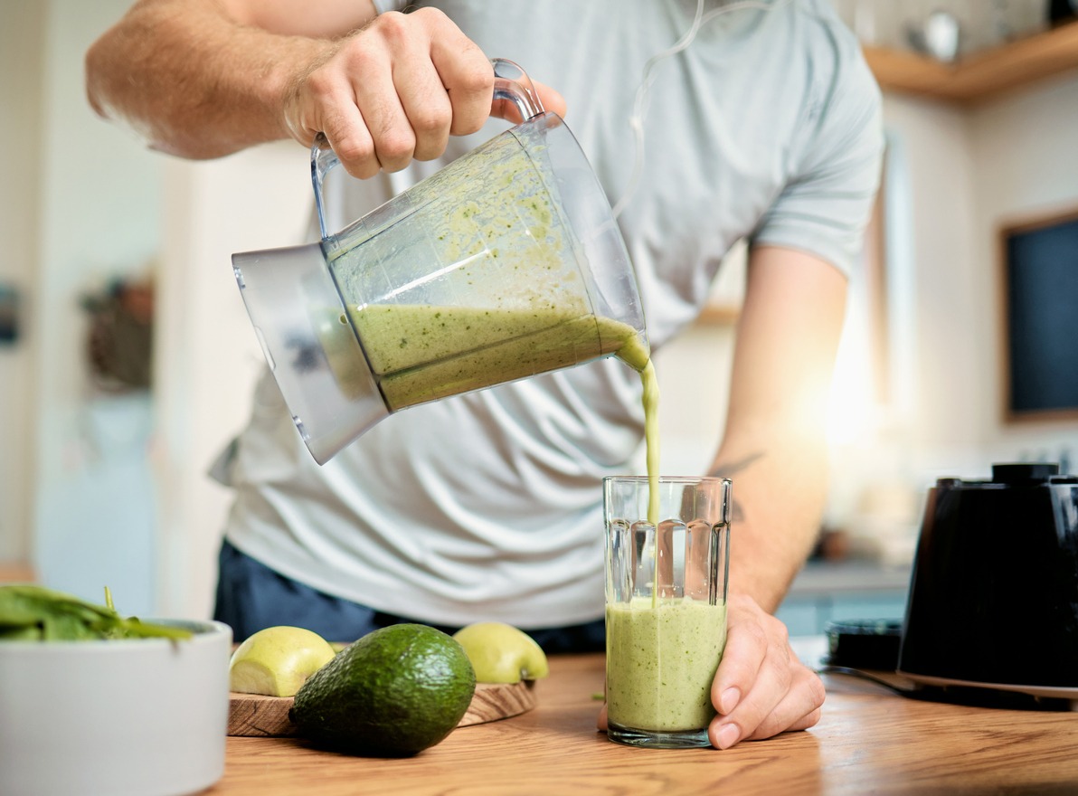 Man pouring healthy smoothie into a glass